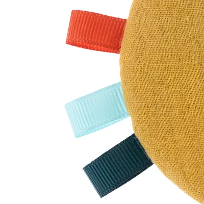 Close-up of a yellow fabric toy with three coloured loops: red, light blue and dark blue.