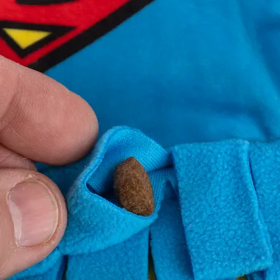 Primo piano di una borsa in tessuto blu con un snack all'interno, mostrato da una mano.