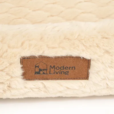 Modern Living logo na hnedom koženom štítku, pripevnenom na krémovej, nadýchanej látke.