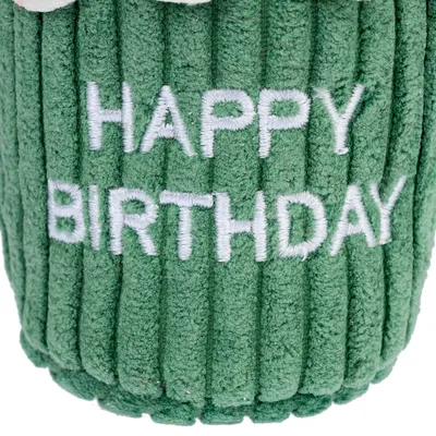 Green fabric toy with embroidered text 'Happy Birthday'.