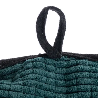 Detailaufnahme eines grünen, gerippten Stoffes mit schwarzer Schlaufe, möglicherweise Teil eines Tierpflegeprodukts oder Zubehörs.