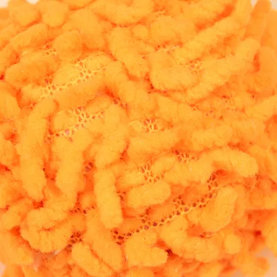 Primo piano di una palla da gioco arancione con superficie morbida, pelosa e struttura a rete.