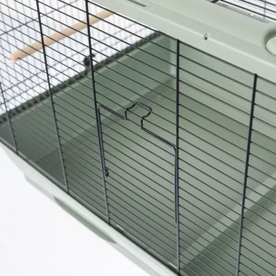 Kooi met zwarte metalen traliewanden, groene bodem en houten zitstok. Detailweergave van de deur met sluitsysteem.