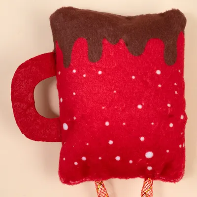 Red plush toy in the shape of a cup with brown foam look and white dots, suitable for pets.