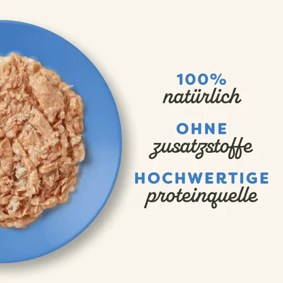 100% natürlich, ohne Zusatzstoffe, hochwertige Proteinquelle. Abgebildet ist zerkleinertes Fleisch auf einem blauen Teller.