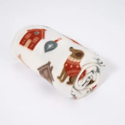 Coperta morbida arrotolata con motivo di cane, ossi, cuccia e ornamenti rossi e verdi su sfondo bianco. Coperta morbida arrotolata con motivo di cane, ossi, cuccia e ornamenti rossi e verdi su sfondo bianco.
