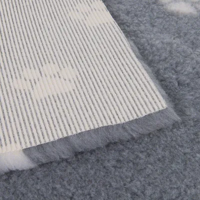 Nahaufnahme einer grauen, weichen Matte mit rutschfester Unterseite aus gestreiftem Material. Geeignet für Haustierbetten oder Liegeflächen.