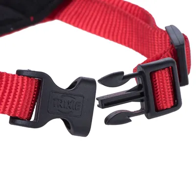 Červený nylonový pásek s černým zacvakávacím uzávěrem, značka Trixie, detailní pohled na uzavírací mechanismus.