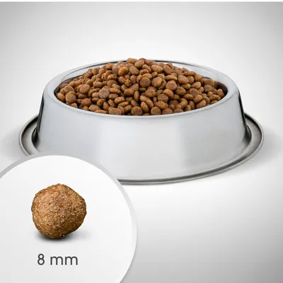 Metallikupissa kuivaruokapaloja, etualalla yksittäinen nappula ja teksti '8 mm' osoittamassa palan halkaisijan. Näkyvissä ei tuotemerkkiä tai muuta tekstiä.