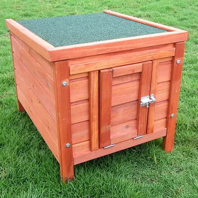 Wooden dog kennel with green roof and metal latch, suitable for outdoor use.