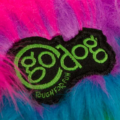 goDog-logo, jossa vihreä teksti 'Tough for Fun' värikkäällä taustalla, jossa on pinkkejä, violetteja ja sinisiä tekoturkiskuituja.