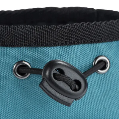 Detailansicht eines blauen Stoffbeutels mit schwarzem Kordelzug und Metallösen.
