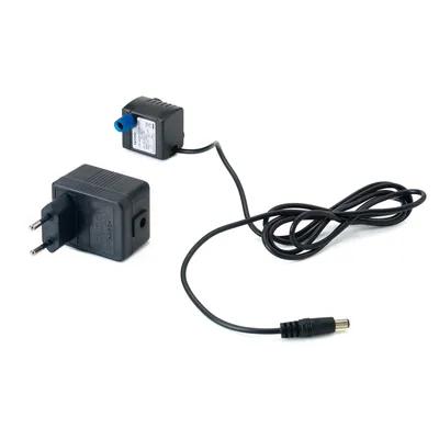 Transformador elétrico preto com ficha europeia, cabo e adaptador ligado. Etiqueta visível com especificações técnicas no adaptador.