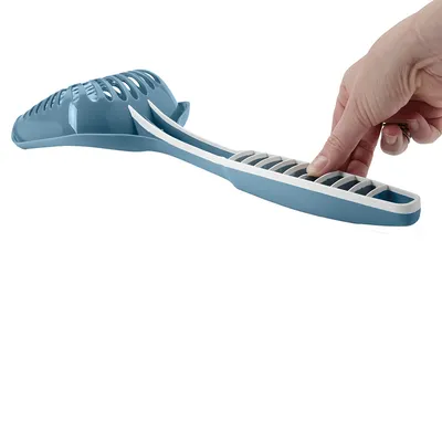 Hand showing the use of a blue cat litter scoop with integrated sieve for easy cleaning.