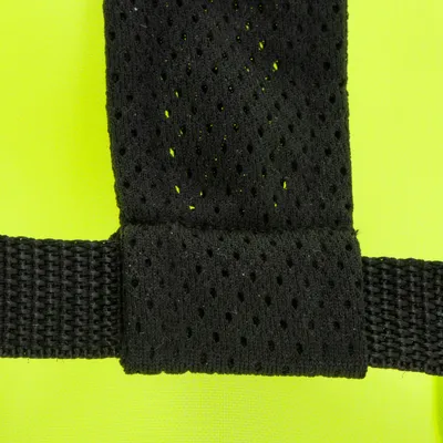 Detaljevisning af sort, åndbart netmateriale med gul baggrund og et solidt bånd.