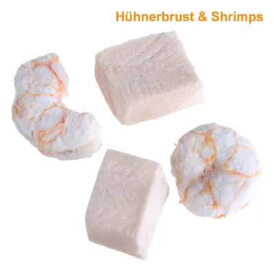 Neljä vaaleaa herkkupalaa, mukana kuutioita ja pyöreitä paloja. Yläreunassa oranssi teksti: Hühnerbrust & Shrimps.