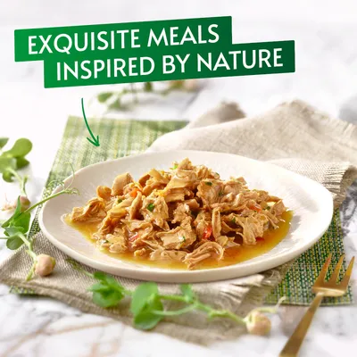 Plate of shredded wet food in gravy with visible herbs, text reads 'Exquisite meals inspired by nature'.