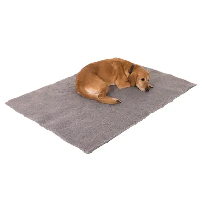 Hund liegt auf einer grauen, flauschigen Matte. Produktbild zeigt Nutzung der Matte als Liegefläche.