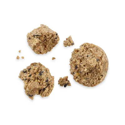 Trozos de alimento húmedo para mascotas, textura granulada con ingredientes visibles en color marrón y negro. Presentación en porciones individuales partidas.