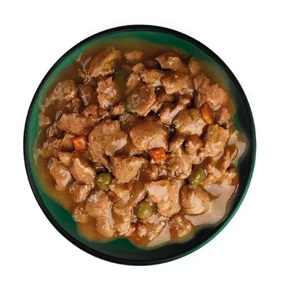Chunks of meat in gravy with visible peas and carrot pieces served in a bowl, showing the texture and ingredients of the wet pet food.