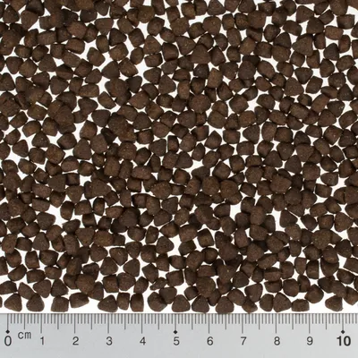 Ruskeita kuivaruokanappuloita, joiden koko näkyy senttimetrimitan avulla (0–10 cm).