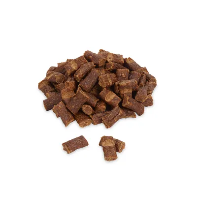 Ein Haufen brauner, rechteckiger Hundesnacks aus getrocknetem Fleisch. Einzelne Stücke sind sichtbar.
