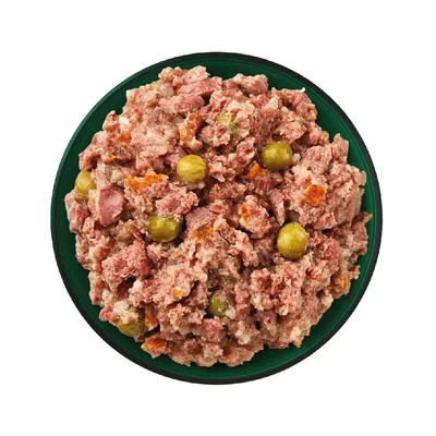 Bowl filled with chunky wet food containing visible pieces of meat, green peas and orange vegetable chunks.