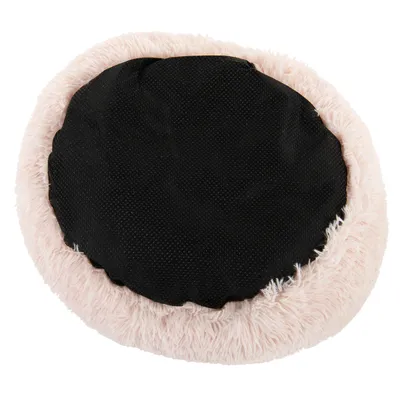 Vue du dessous d’un coussin rond pour animal, surface inférieure noire antidérapante et rebord en tissu peluche rose clair.