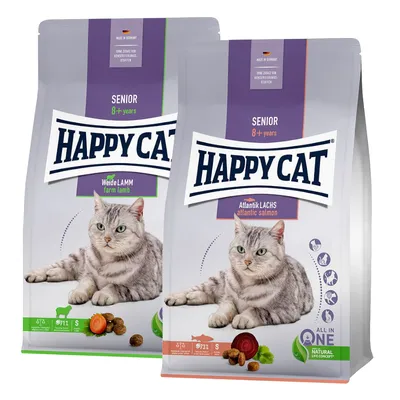 To poser Happy Cat kattefoder til senior 8+ år: Weide Lamm farm lamb og Atlantik Lachs atlantic salmon. Billede af kat, foderpiller og grøntsager på begge poser.