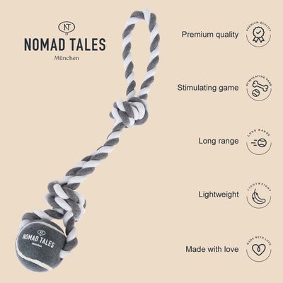 Juguete de cuerda y pelota gris-blanca con texto visible: NOMAD TALES München. Inscripciones en inglés: Premium quality, Stimulating game, Long range, Lightweight, Made with love.