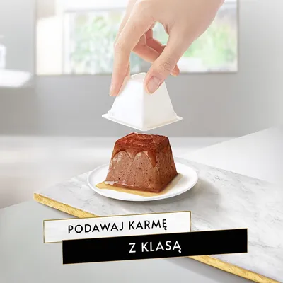 Porcja mokrej karmy na białym talerzyku, zdejmowane opakowanie. Widoczny napis: Podawaj karmę z klasą.