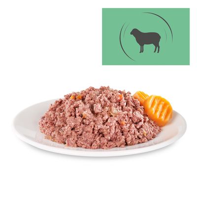 Portion vådfoder med kødstykker og grøntsager på en hvid tallerken, symbol af et får øverst til højre i billedet.