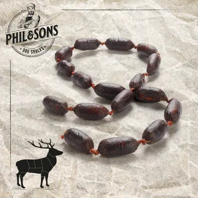 Saucisses pour chien Phil & Sons, présentées en chapelet, logo Phil & Sons Dog Snacks et silhouette de cerf visibles sur l’image.