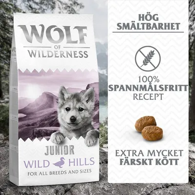 Wolf of Wilderness Junior Wild Hills torrfoder. Text: Hög smältbarhet, 100 % spannmålsfritt recept, extra mycket färskt kött. Bild på två foderbitar.