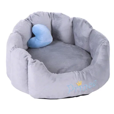 Letto per animali grigio e rotondo con imbottitura morbida e cuscino a forma di cuore blu. Ricamo 'Prince' con corona dorata visibile. Letto per animali grigio e rotondo con imbottitura morbida e cuscino a forma di cuore blu. Ricamo 'Prince' con corona dorata visibile.