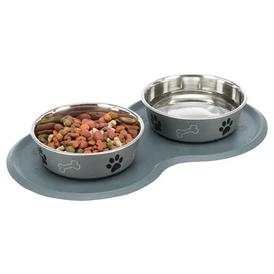 Doppelnapf-Set mit grauer Unterlage, zwei Edelstahlnäpfen: einer gefüllt mit Trockenfutter, der andere leer. Design mit Pfoten- und Knochenmotiven.