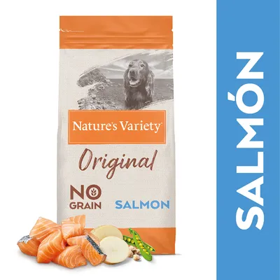 Nature's Variety Original Salmon koiranruokapakkaus, tekstit: NO GRAIN, SALMON. Edessä lohipaloja, omenaa, herneitä ja pähkinöitä. Oikealla iso teksti: SALMÓN.