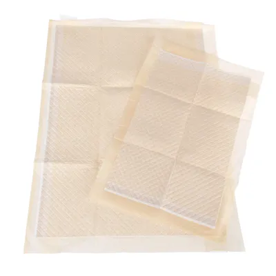 Due tappetini assorbenti rettangolari di colore beige con superficie trapuntata, mostrati sovrapposti su fondo bianco. Materiale plastico visibile ai bordi.