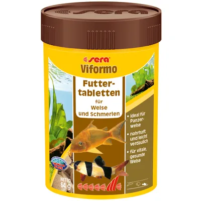 Упаковка Sera Viformo Futtertabletten für Welse und Schmerlen, 64 г. Видны изображения двух аквариумных рыб и текст на немецком языке о питательных свойствах.