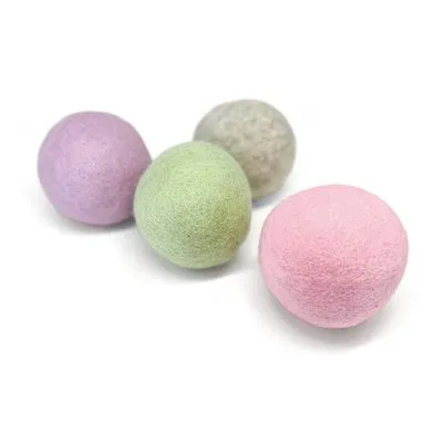 Vier vilten speelballen in pastelkleuren: roze, groen, paars en grijs. Materiaal: vilt. Geen merknaam of tekst zichtbaar.