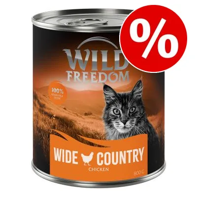 Conservă Wild Freedom Wide Country Chicken 800 g, imagine cu pisică și etichetă „100% grain-free recipe”, simbol procent pentru promoție.