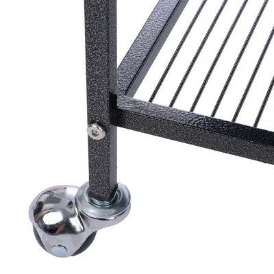 Détail d’une étagère ou cage en métal avec roulette pivotante en métal fixée au pied, structure à barreaux visible.