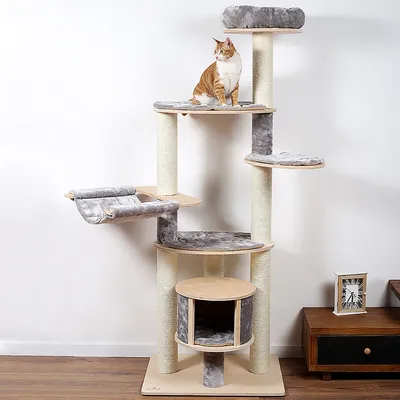 Kratzbaum mit mehreren Ebenen, Sisalstämmen und grauen Liegeflächen. Integrierte Höhle und Hängematte. Roter-weisser Katze sitzt auf oberster Plattform.