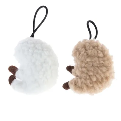 Två plyschleksaker i fårform, en vit och en beige, med svarta öglor för upphängning.
