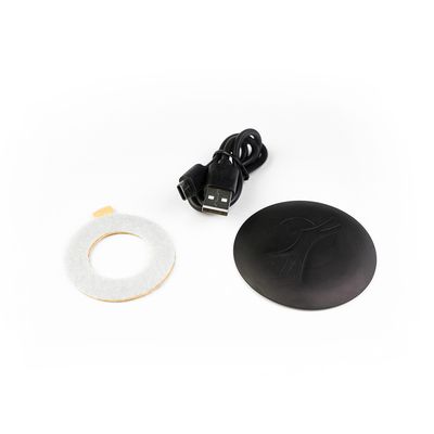 Produktset bestehend aus USB-Kabel, schwarzem Kunststoffdeckel mit Logo und rundem Filzring. Zubehör für elektronische Geräte.