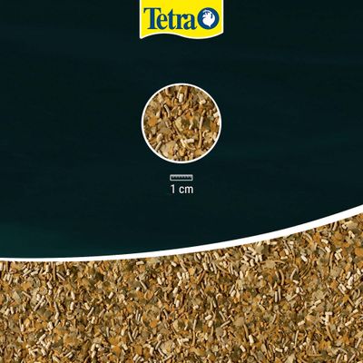 Tetra Logo, primo piano dei fiocchi di mangime con scala di 1 cm per visualizzare la dimensione dei pezzi di mangime.