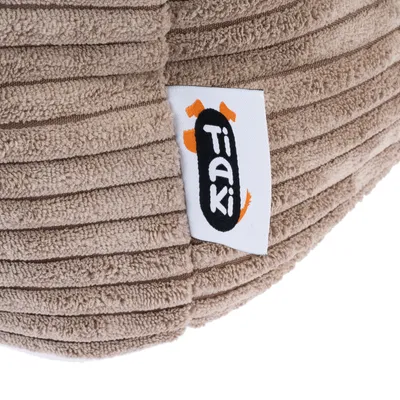 Tiaki-logo op een bruin, geribd stoffen label.