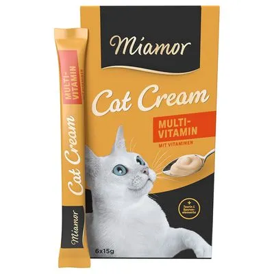 Miamor Cat Cream Multi-Vitamin, verpakking met afbeelding van witte kat, tekst: MULTI-VITAMIN MIT VITAMINEN, 6x15g, plus taurine & sporenelementen. Stick en doos zichtbaar.