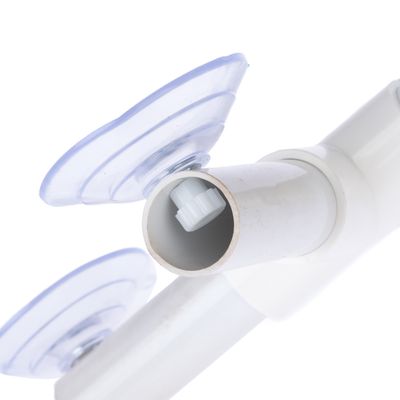 Detailní záběr na bílé plastové potrubí se dvěma průhlednými přísavkami a šroubovacím mechanismem uvnitř.