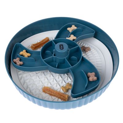 Rundes, blau-weisses Futterspielzeug mit mehreren Fächern, gefüllt mit kleinen Knochenförmigen Leckerlis und einem Kausnack.